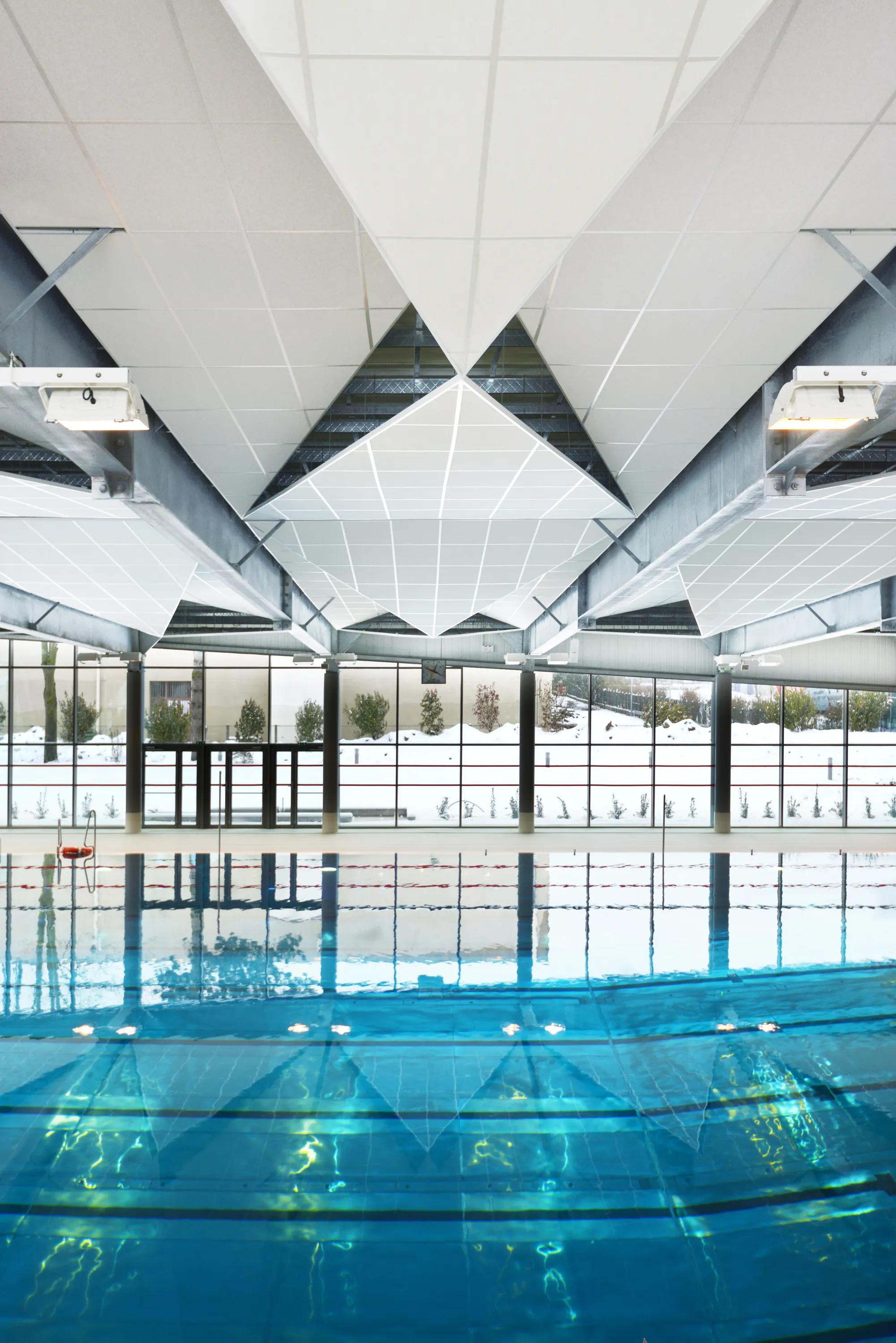 Faceted Acoustic Ceiling Island with white ceiling tiles at a swimming pool.