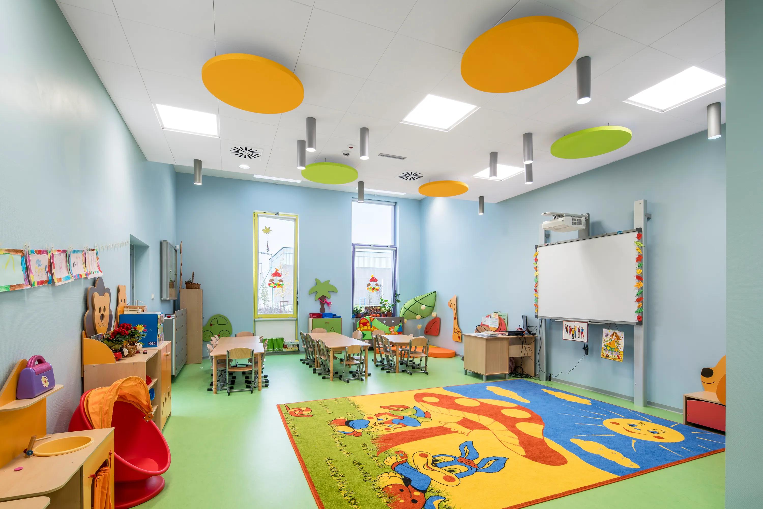classroom ceiling with customised orange and green acoustic islands in round shape