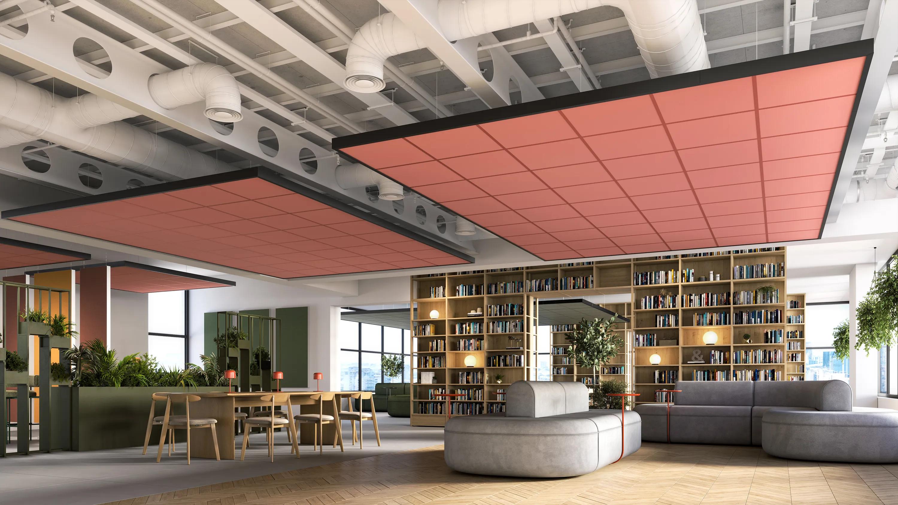 Open office lounge and library space with bookshelves, seating areas, and large suspended red acoustic ceiling panels beneath exposed ductwork and services.