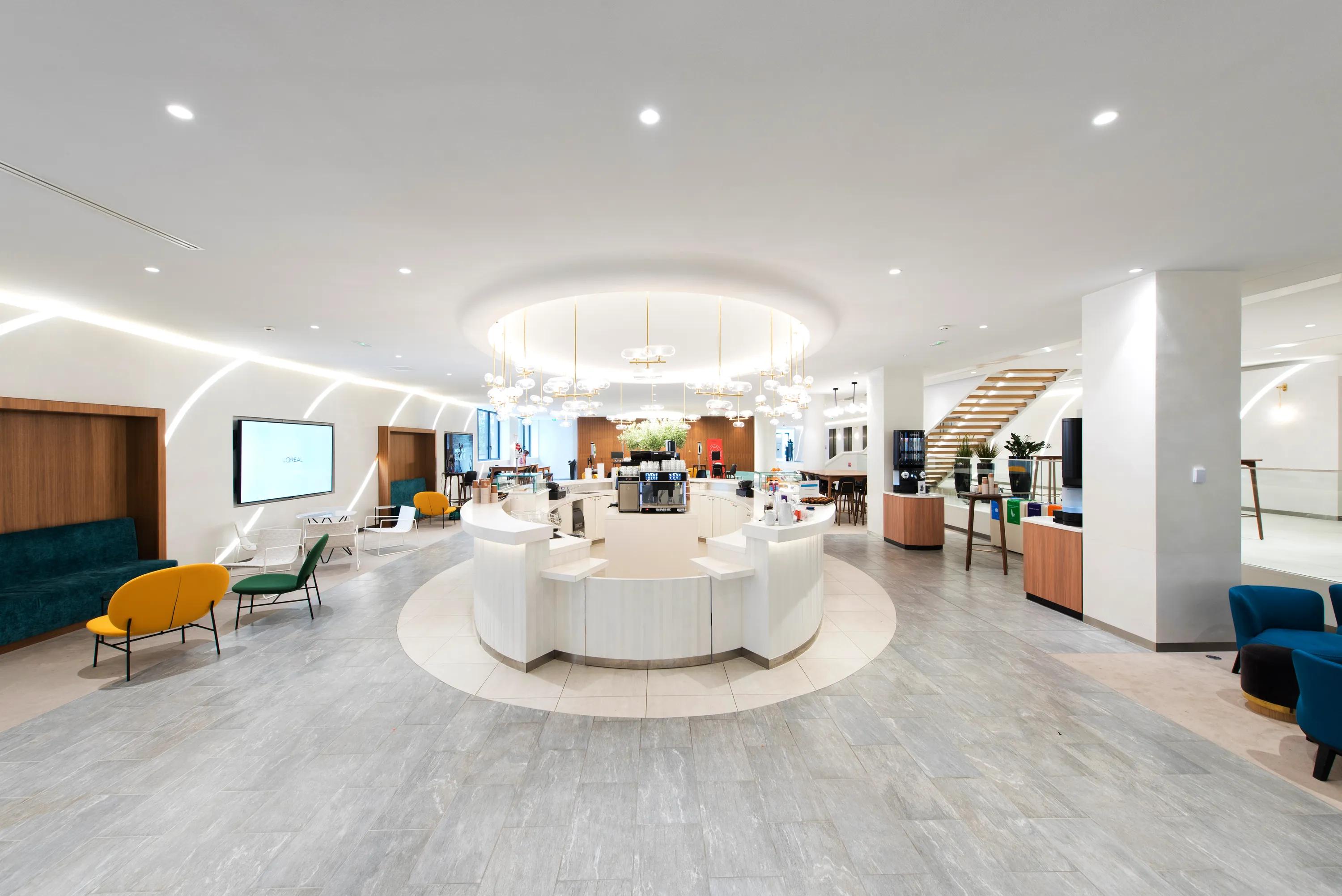 Bright, modern white seamless office ceiling with circular white desk, stylish seating, and contemporary lighting. Neutral tones and sleek design.
