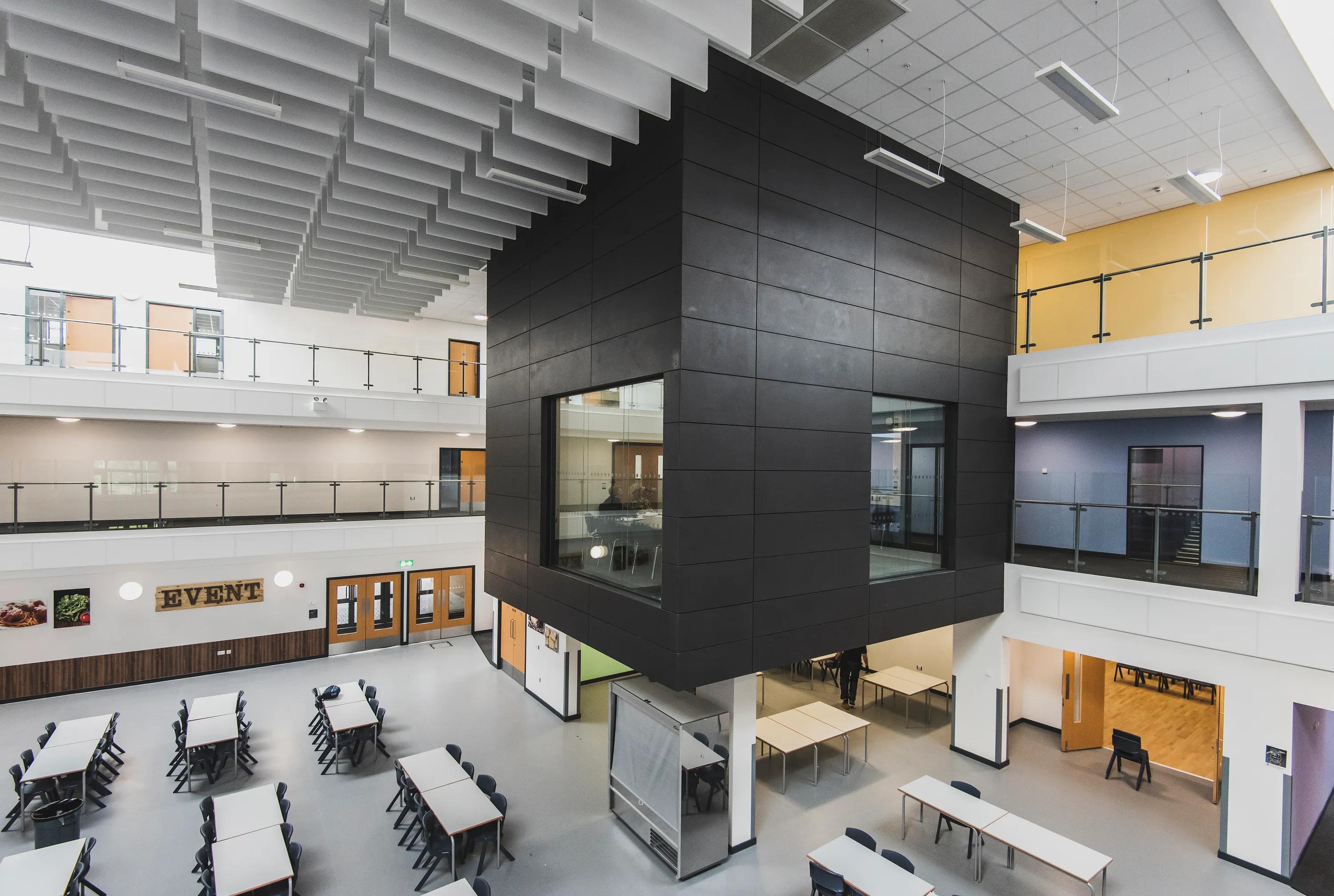 A baffle ceiling at Littleport Academy, Atkins, School, Rockfon Blanka dB40, A edge, 600x600, white, Chicago Metallic T24, Rockfon Color-all wall panel, Rockfon Contour Baffle, 1200x300, white, breeze