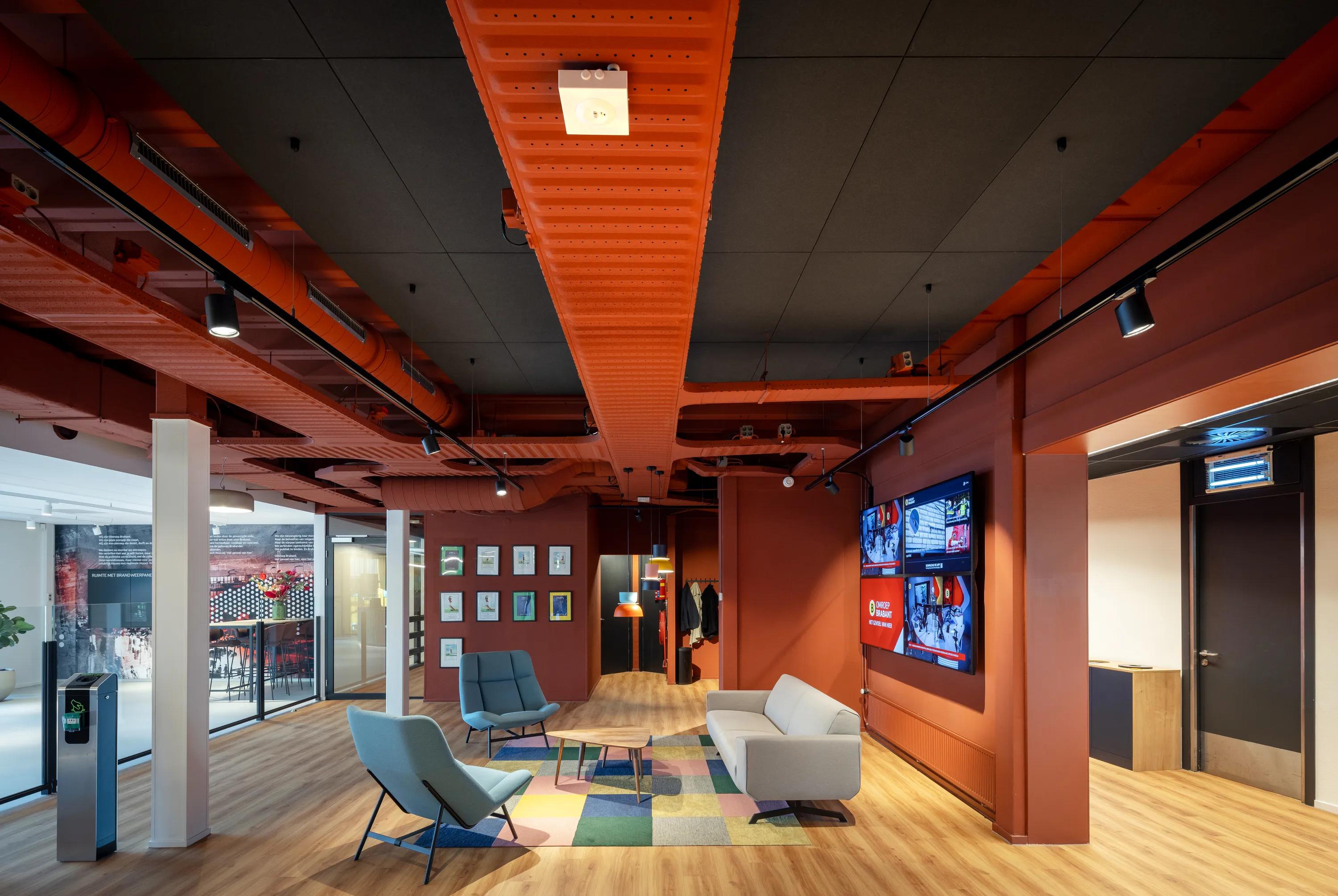 An open plan office with black adhesive ceiling tiles and exposed Industrial services.