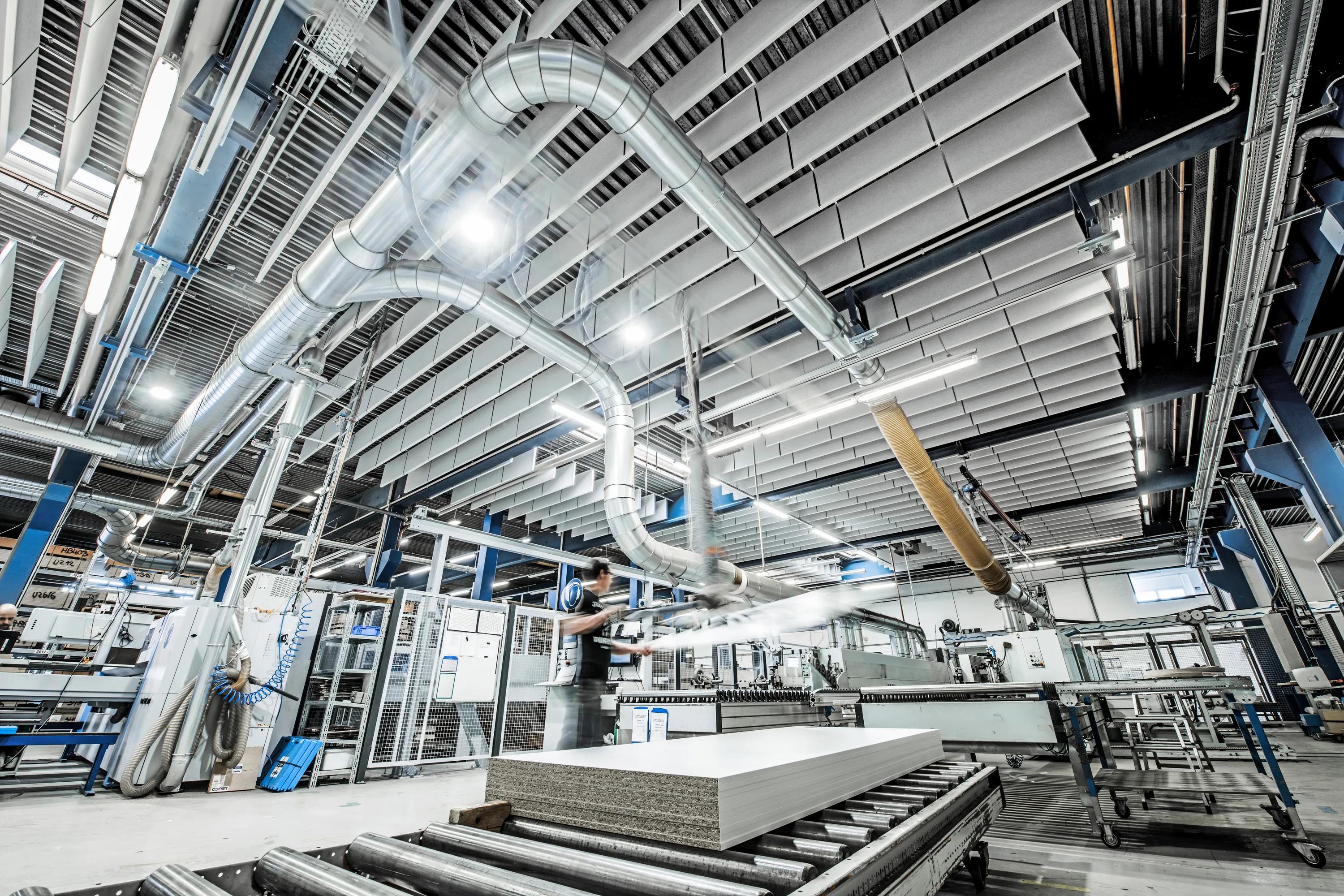 A production facility with optimised acoustics using acoustic ceiling tiles and a ceiling grid.