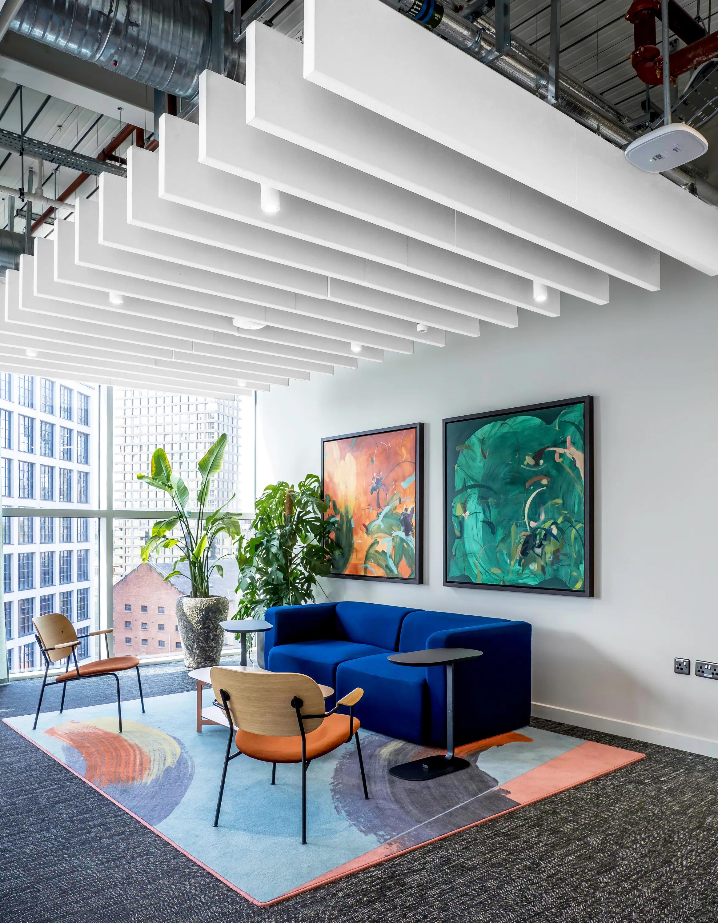 An open plan ceiling with white acoustic ceiling baffles